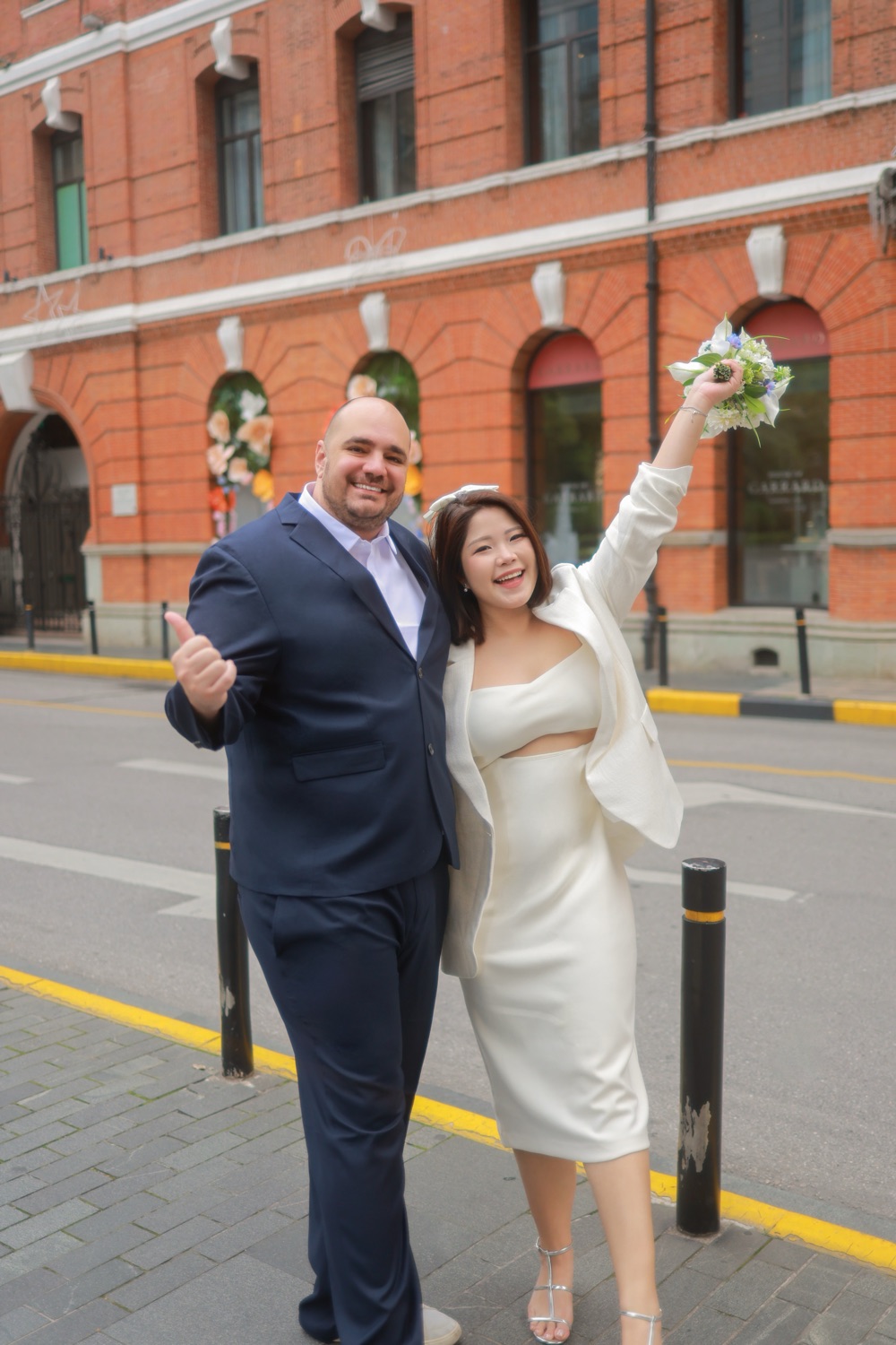 Laughing together, bouquet raised high